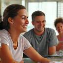 A diverse group of active adults smiling and collaborating in a vibrant, modern community space, symbolizing supportive group coaching and connection.