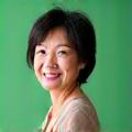 Portrait of Vitalbloom client Sarah Chen, 52, smiling confidently.
